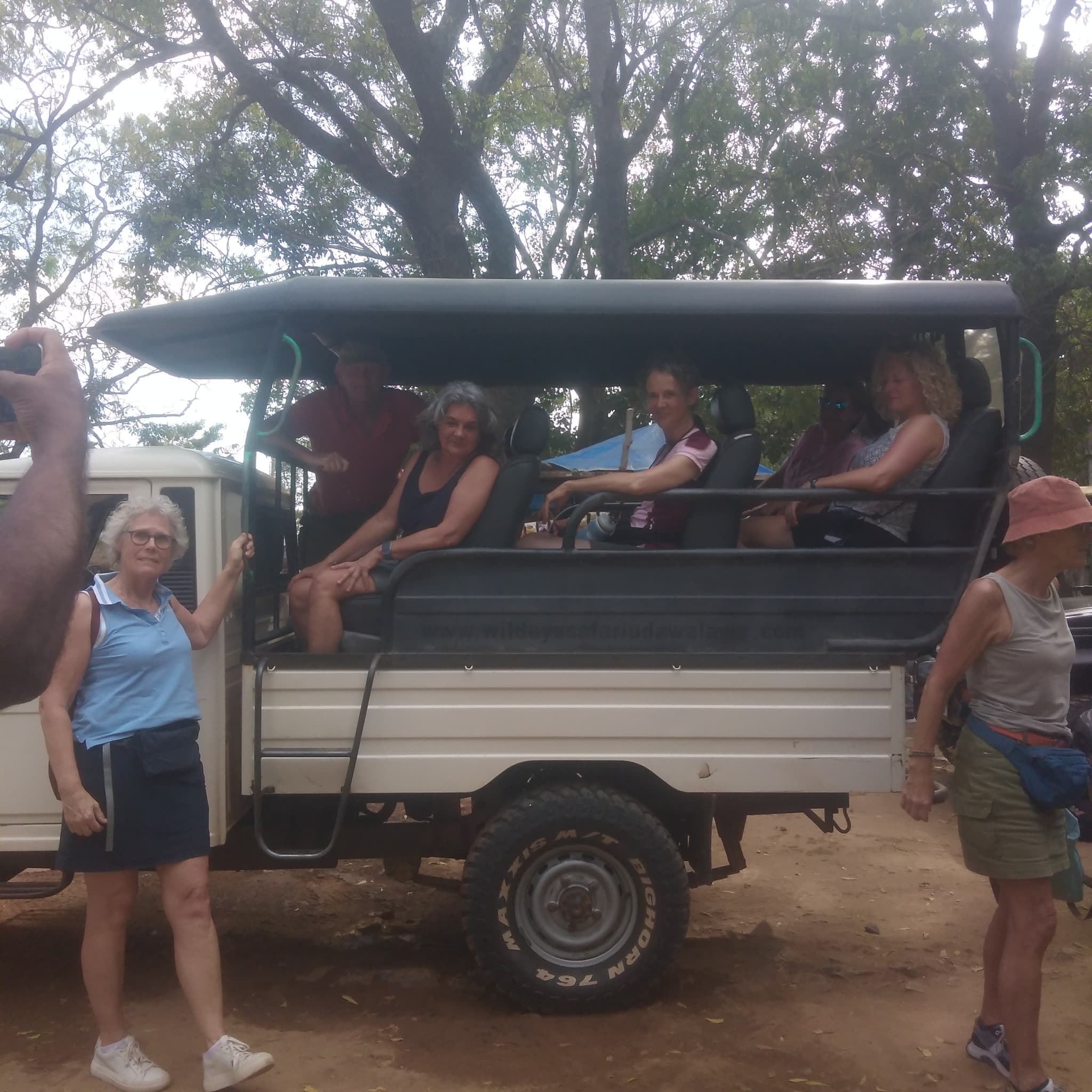 Family sitting quietly and attentively in a safari jeep during a calm period between sightings at Yala National Park