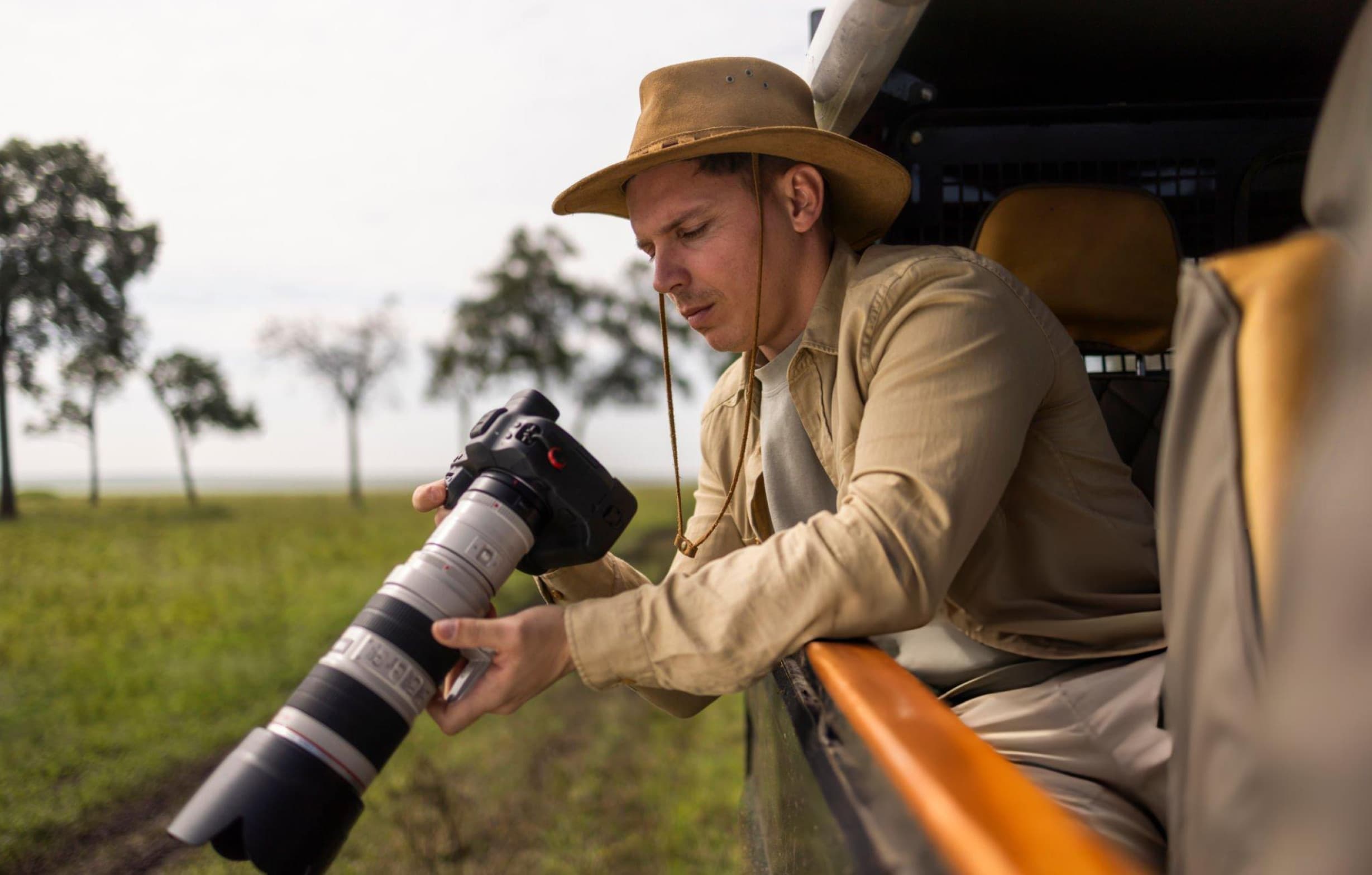 Wildlife photographer reviewing morning safari images on a laptop inside a jeep during midday rest at Yala National Park